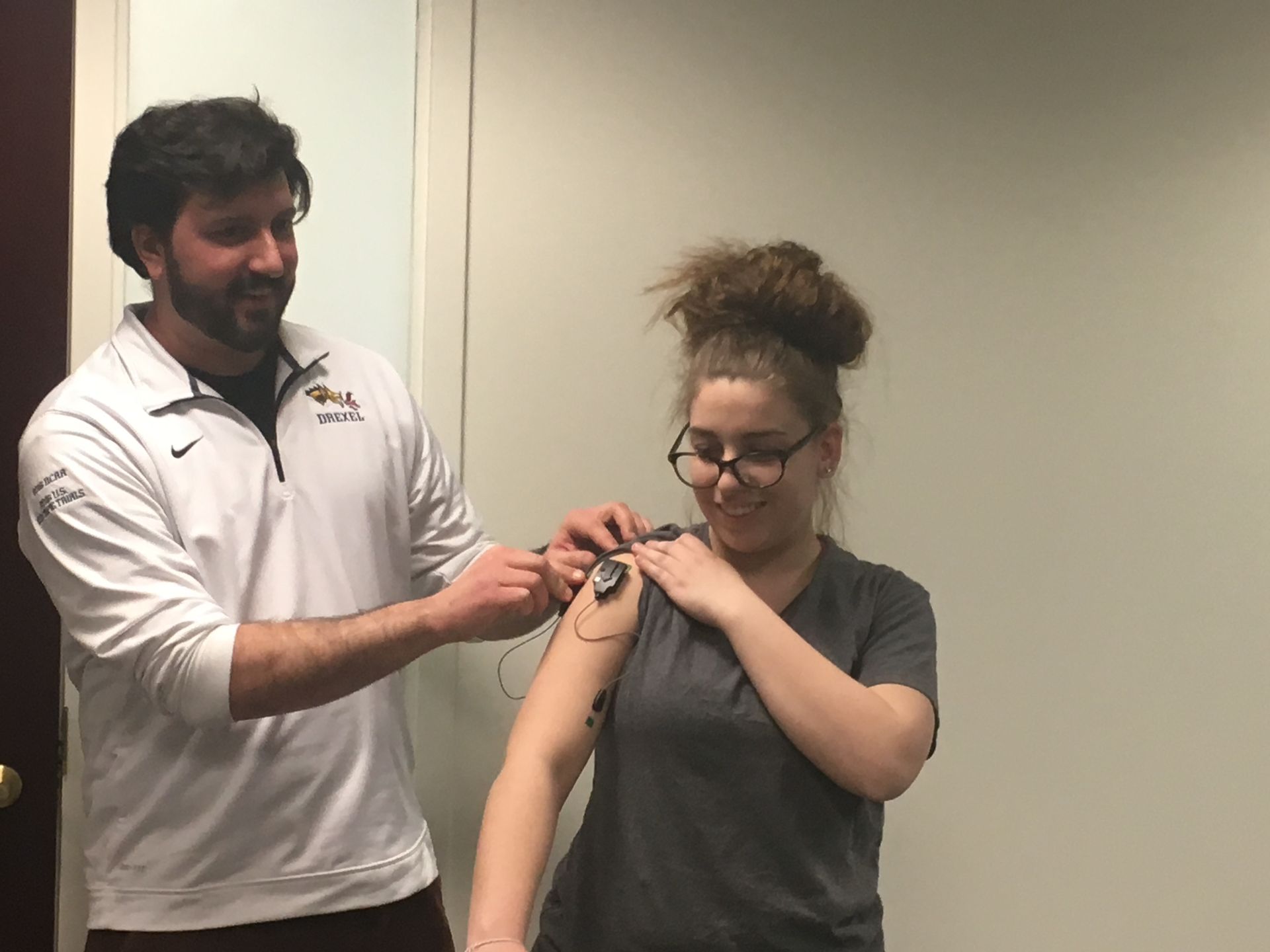 A Drexel graduate student attaches a motion sensor to a student's arm during National Biomechanics Day 2018