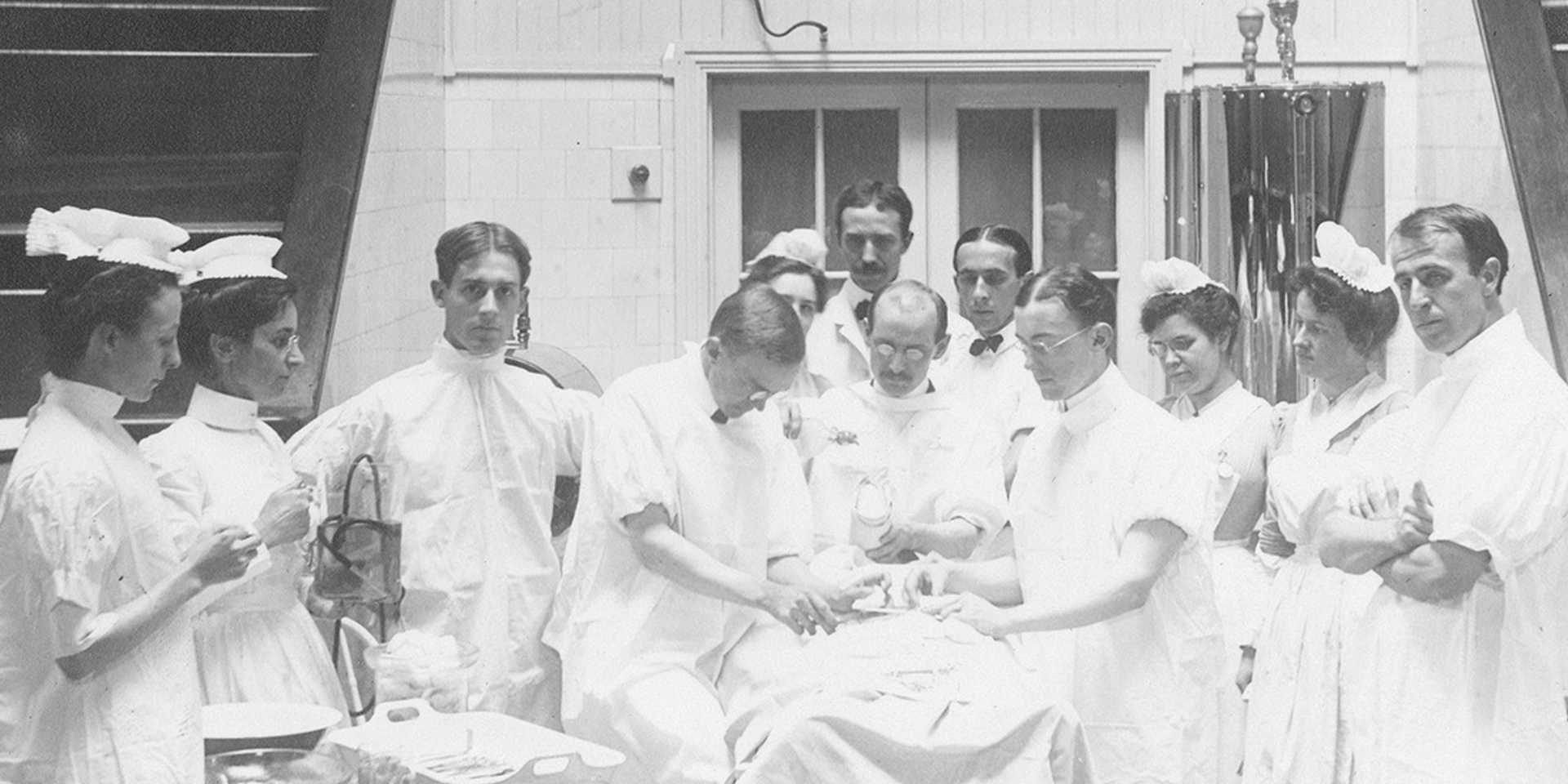 Black and white historical photo of doctors and nurses during operation