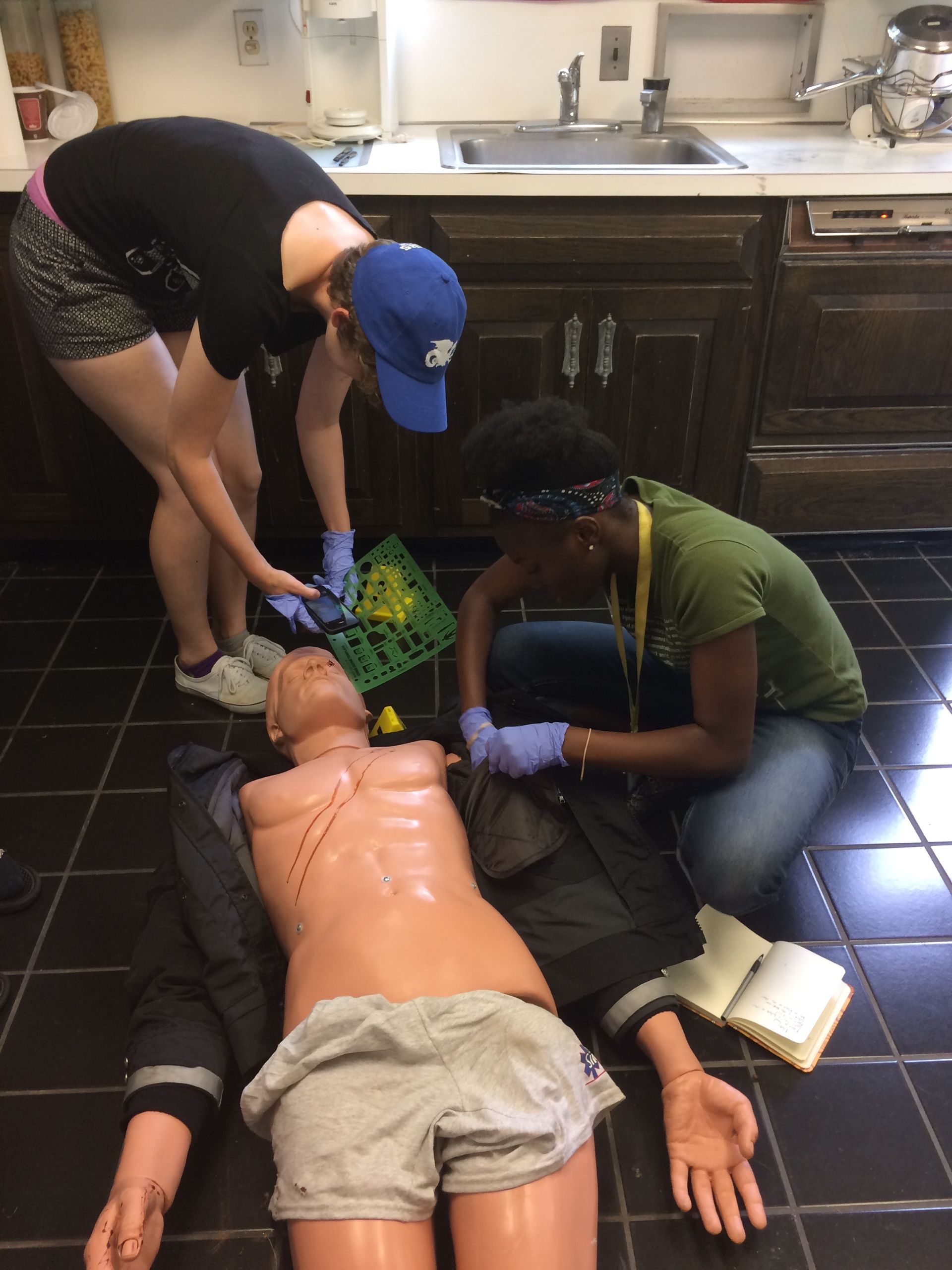Students from the Center for Education's youth programs gather evidence from a human dummy simulating a victim at the Arcadia Crime Scene House