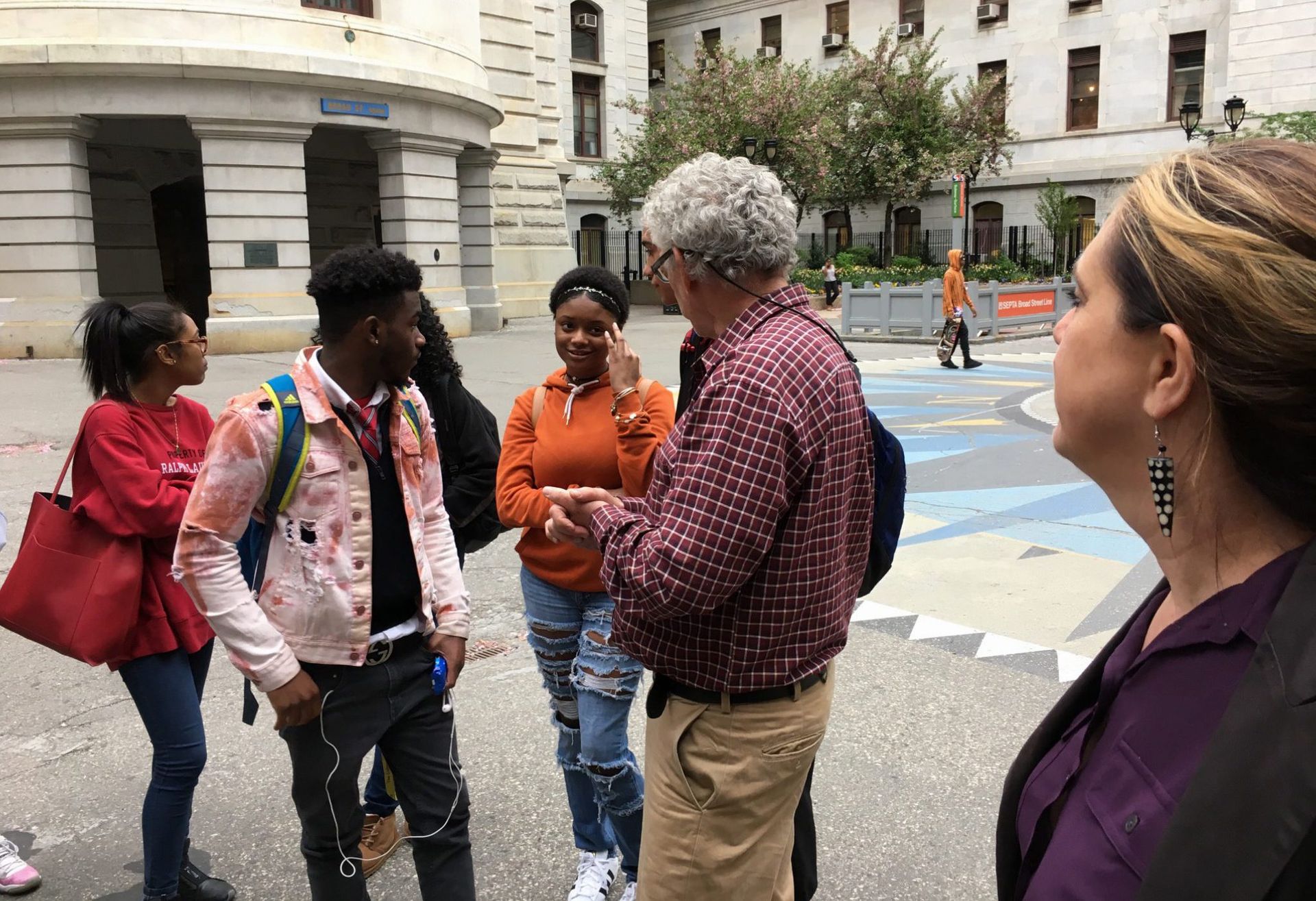 Students in the Karabots Junior Fellows Program talk with Michael Nairn, Professor of Urban Planning at Penn, in the courtyard of Philadelphia City Hall