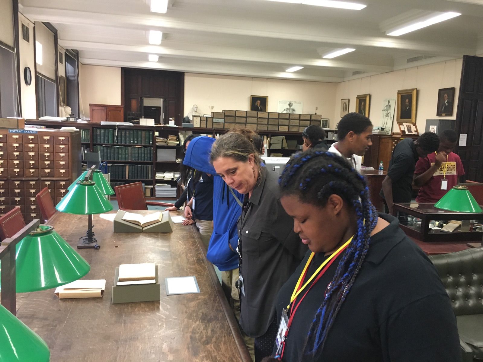 Students in the Karabots Junior Fellows Program examine a set of challenged books on display at the Historical Medical Library