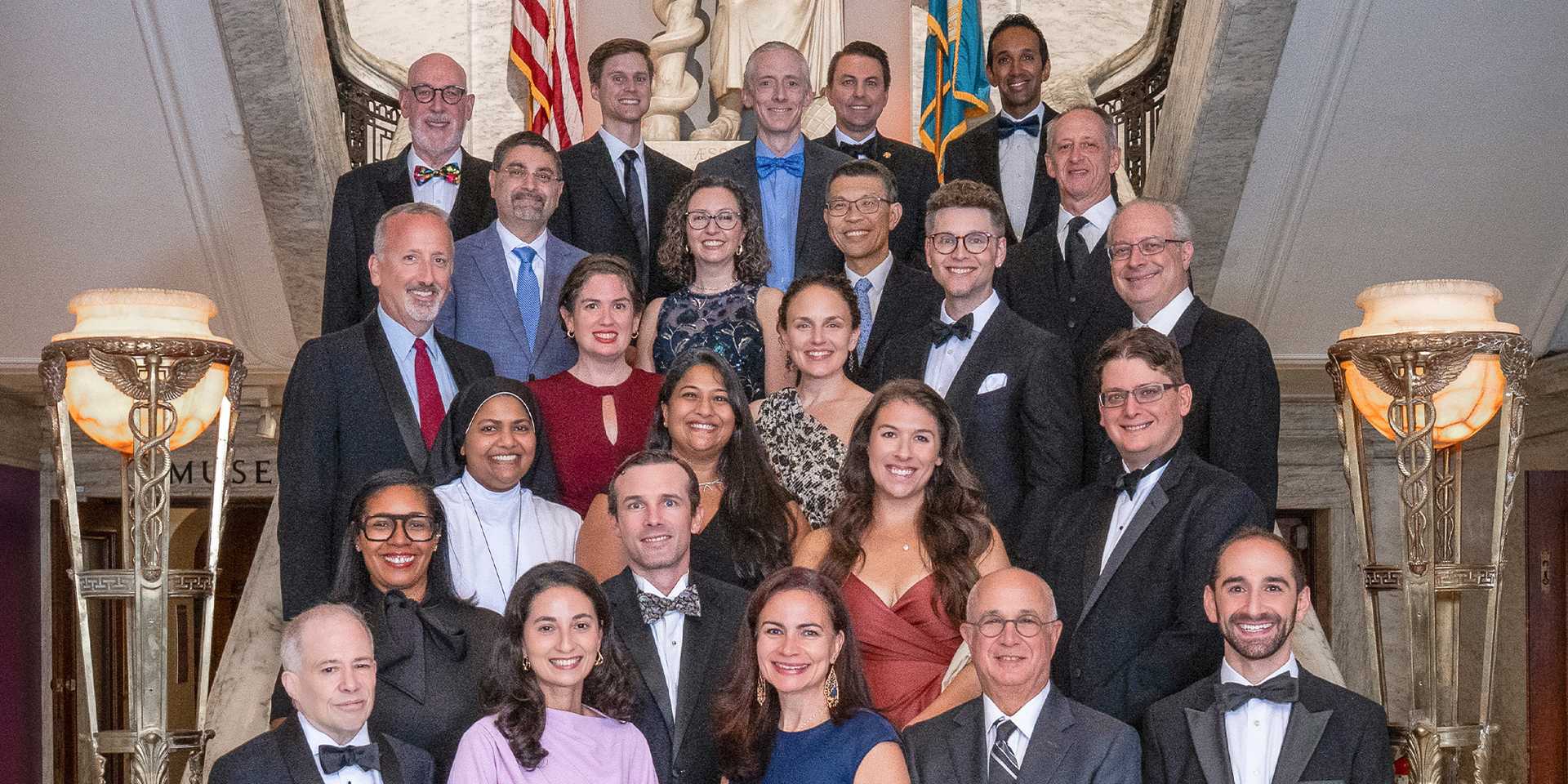 Group of newly inducted Fellows standing along a flight of stairs