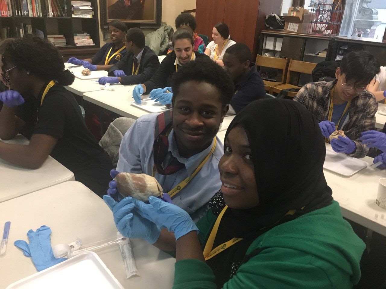 Students in the Karabots Junior Fellows program hold up a sheep heart during a sheep heart dissection.
