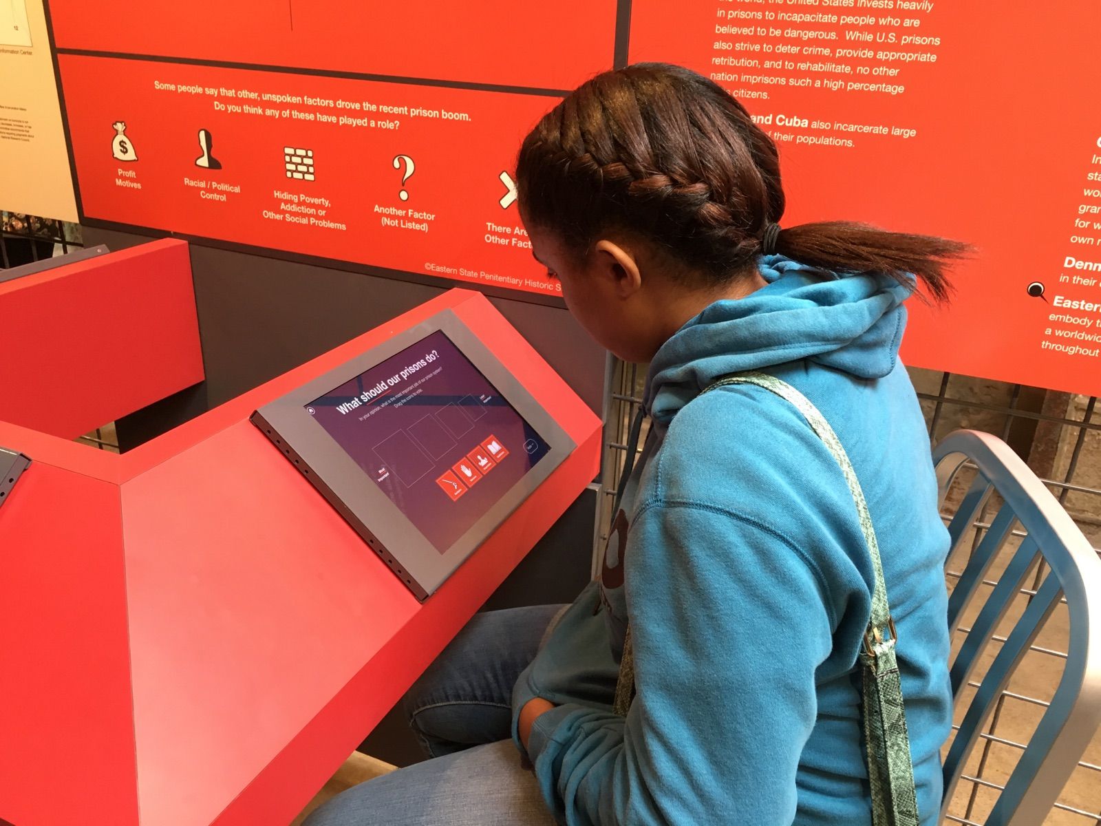 One of the Teva fellows interacts with a touch screen-based poll at Prison's Today, an exhibit on mass incarceration at Eastern State Penitentiary