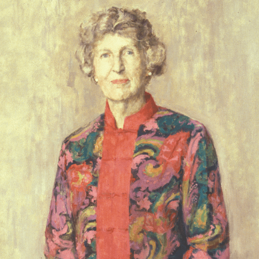 Portrait of a woman in a multicolored dress with pearl earrings and short, curly hair