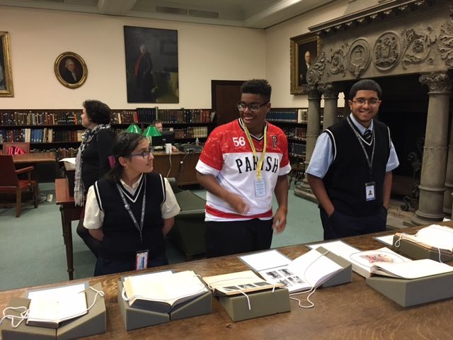 Three students from the Karabots Junior Fellows program stand in front of books on display in the Historical Medical Library for the Banned Books Week exhibit