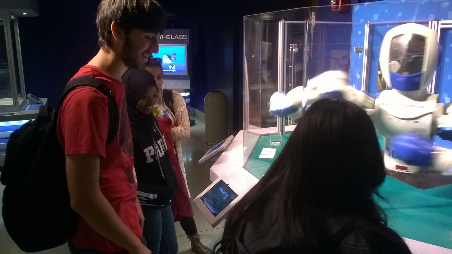 Students in the Teva Pharmaceuticals Internship Program play blackjack with a robot at the Robot Revolution exhibit at the Franklin Institute