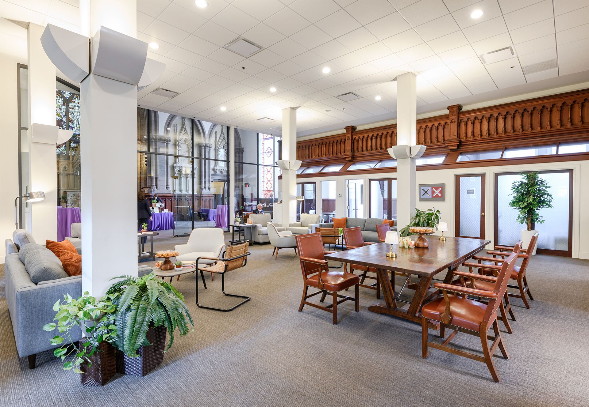 Photo of a large room with tables and chairs, couches, and side offices